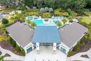 A large swimming pool with a blue roof, surrounded by palm trees and lounge chairs. - Prime Location w/ Game Room Veranda Palms Resort (Kissimmee)