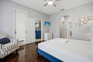 A hotel room with a bed, a chair, a desk, and a view of the kitchen. - Near Disney Pool Home with Minions & Mickey Rooms (Kissimmee)