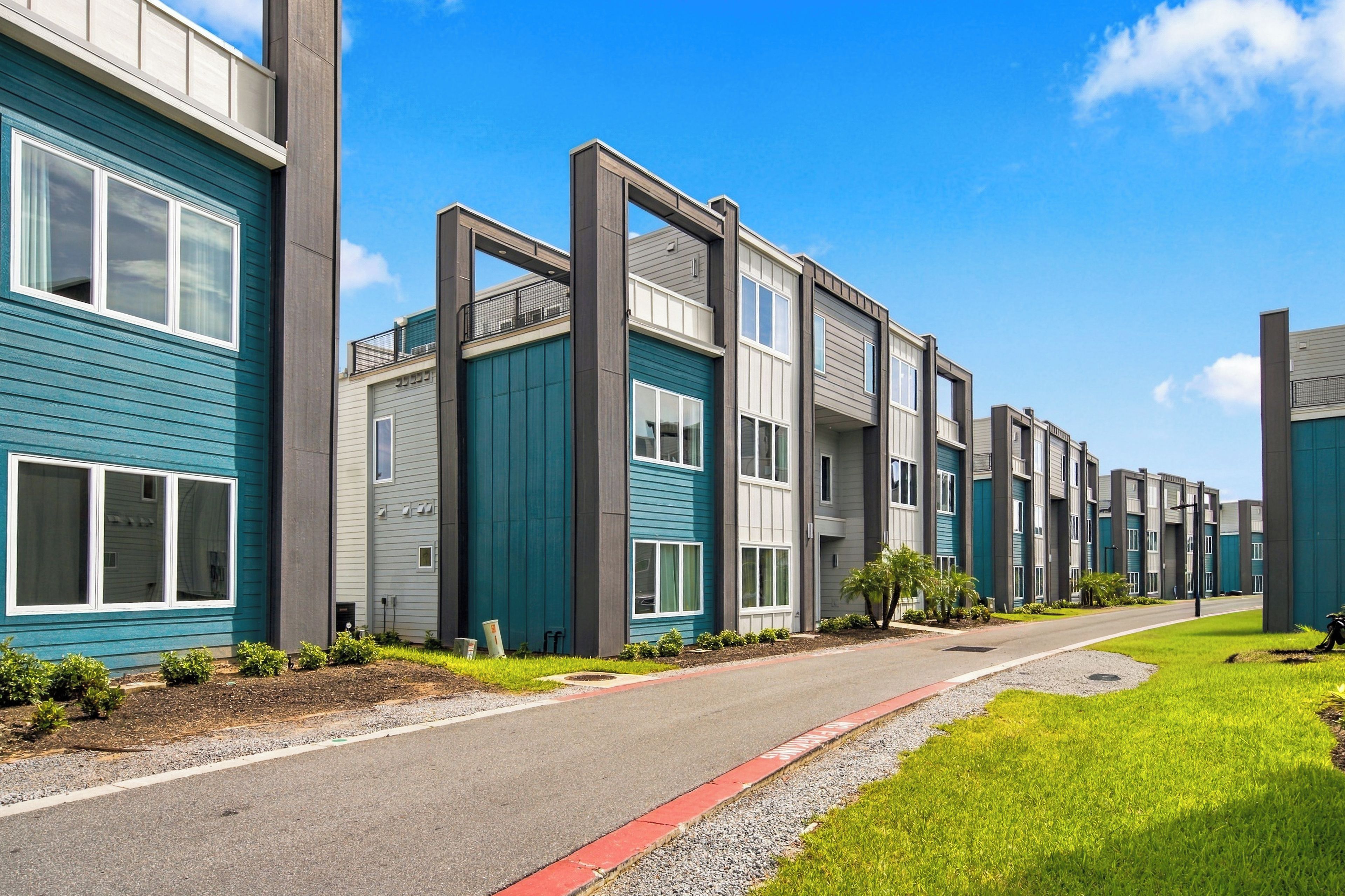 Una hilera de edificios residenciales modernos de varios pisos con un estilo arquitectónico uniforme, caracterizados por grandes ventanales y un techo plano.