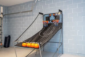 A basketball hoop with a net, mounted on a wall with a brick pattern.