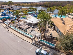 Una vista aerea di un resort con piscina, scivoli acquatici e una zona ristoro.