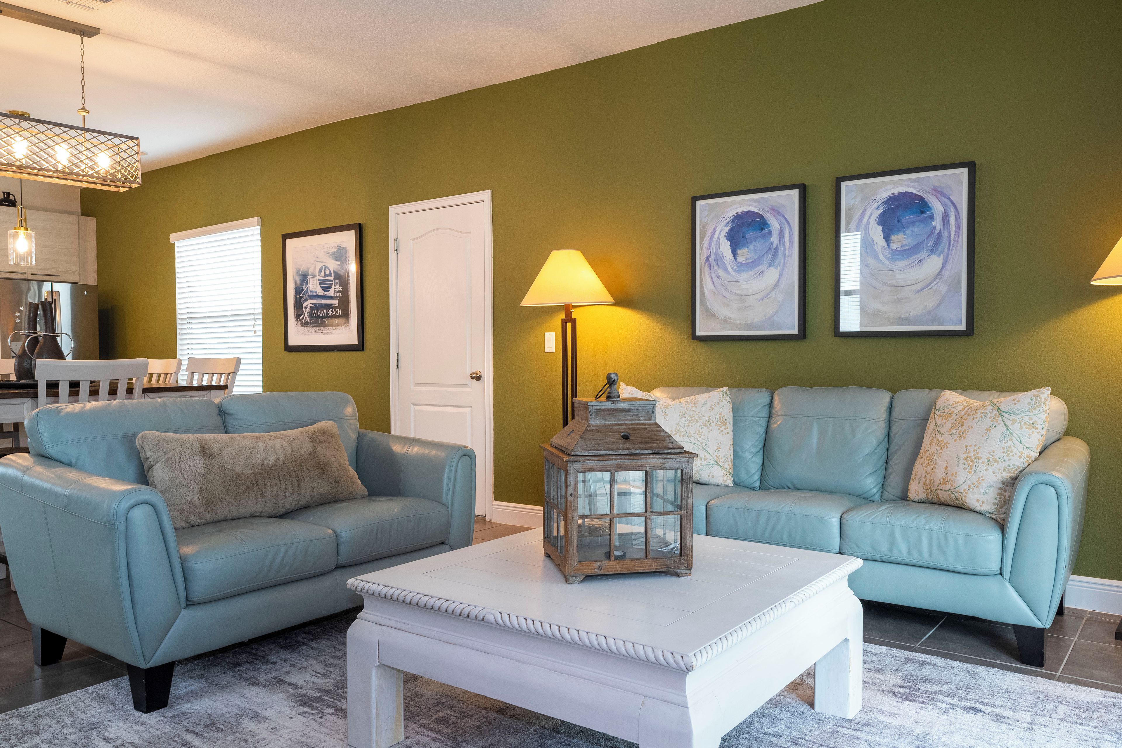 A living room with two sofas, a coffee table, a lamp, and artwork on the wall.