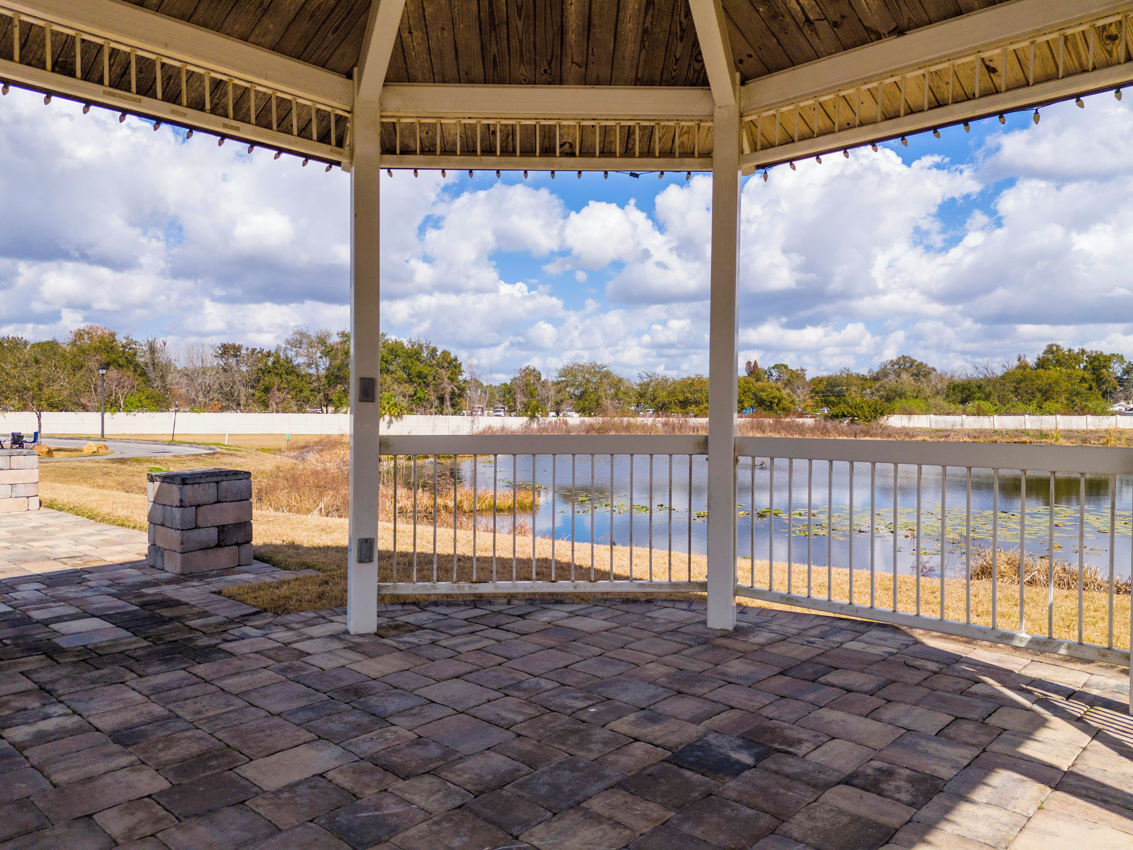 Um pavilhão coberto com vista para um lago e árvores.