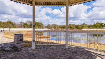 Um pavilhão coberto com vista para um lago e árvores.