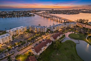 A hotel with multiple buildings, a parking lot, and a river with a bridge in the background. - Bayfront Condo Big Views Private Beach & Pool (St. Petersburg)
