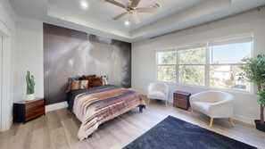 A bedroom with a bed, a ceiling fan, a large window, and a view of the outside. - Rodeo House Downtown Houston (Houston)