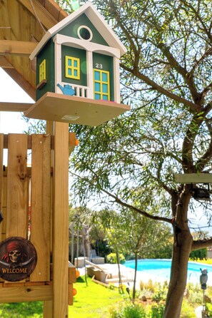 A wooden structure with a house-shaped decoration, a welcome sign, and a tree in the background. - Villa Dryas a traditional private pool villa,in the riviera of Attica,Lagonisi (Kalivia Thorikou)