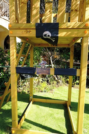 A wooden pirate-themed chair with a skull and crossbones flag, a welcome sign, and a small lizard decoration. - Villa Dryas a traditional private pool villa,in the riviera of Attica,Lagonisi (Kalivia Thorikou)