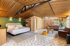 Ein modernes Schlafzimmer mit einem großen Bett, einer Couch und einem kleinen Tisch.