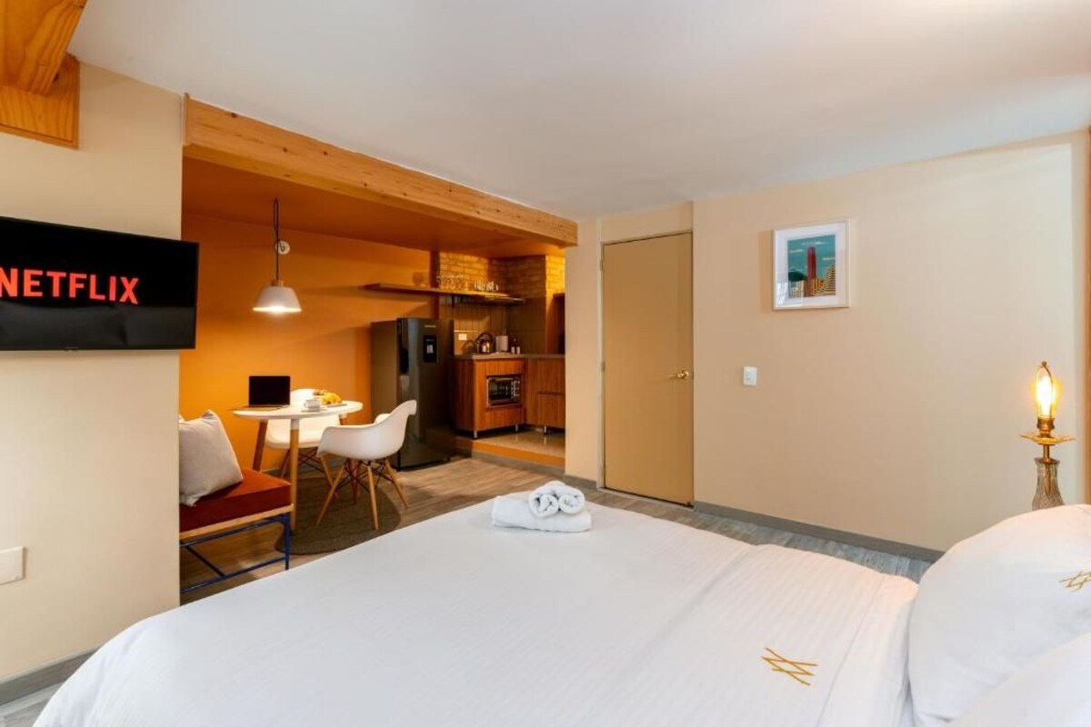 Ein Hotelzimmer mit Bett, Schreibtisch, Stuhl, Fernseher und Tür.