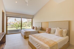 A bedroom with two beds, a large window, and a view of greenery outside. - Luxury Villa in El Tigre with Beach Club (Nuevo Nayarit)