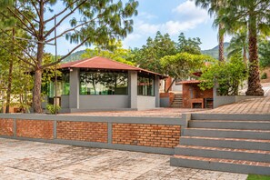 A modern building with a brick facade, large windows, and a red roof. - Vrbo Property (Oaxaca de Juárez)