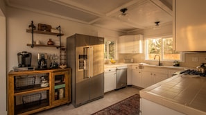 Eine moderne Küche mit einem Edelstahl-Kühlschrank, Holzschränken und einem eingebauten Geschirrspüler.