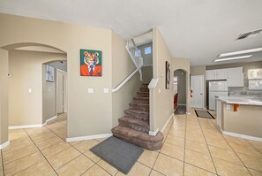 A residential interior with a staircase, kitchen, and living area. - I-5 Getaway, Sleek & Spacious. All Fees included (Stockton)