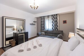 A hotel room with a bed, a dresser, a mirror, a sofa, and a window with curtains. - SODIC Kattameya Plaza, 3-Bedroom, 230 m² Family Apartment, 3 Pools in New Cairo (New Cairo)