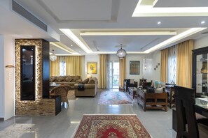 A spacious living area with a sofa set, a coffee table, and a patterned rug. - SODIC Kattameya Plaza, 3-Bedroom, 230 m² Family Apartment, 3 Pools in New Cairo (New Cairo)