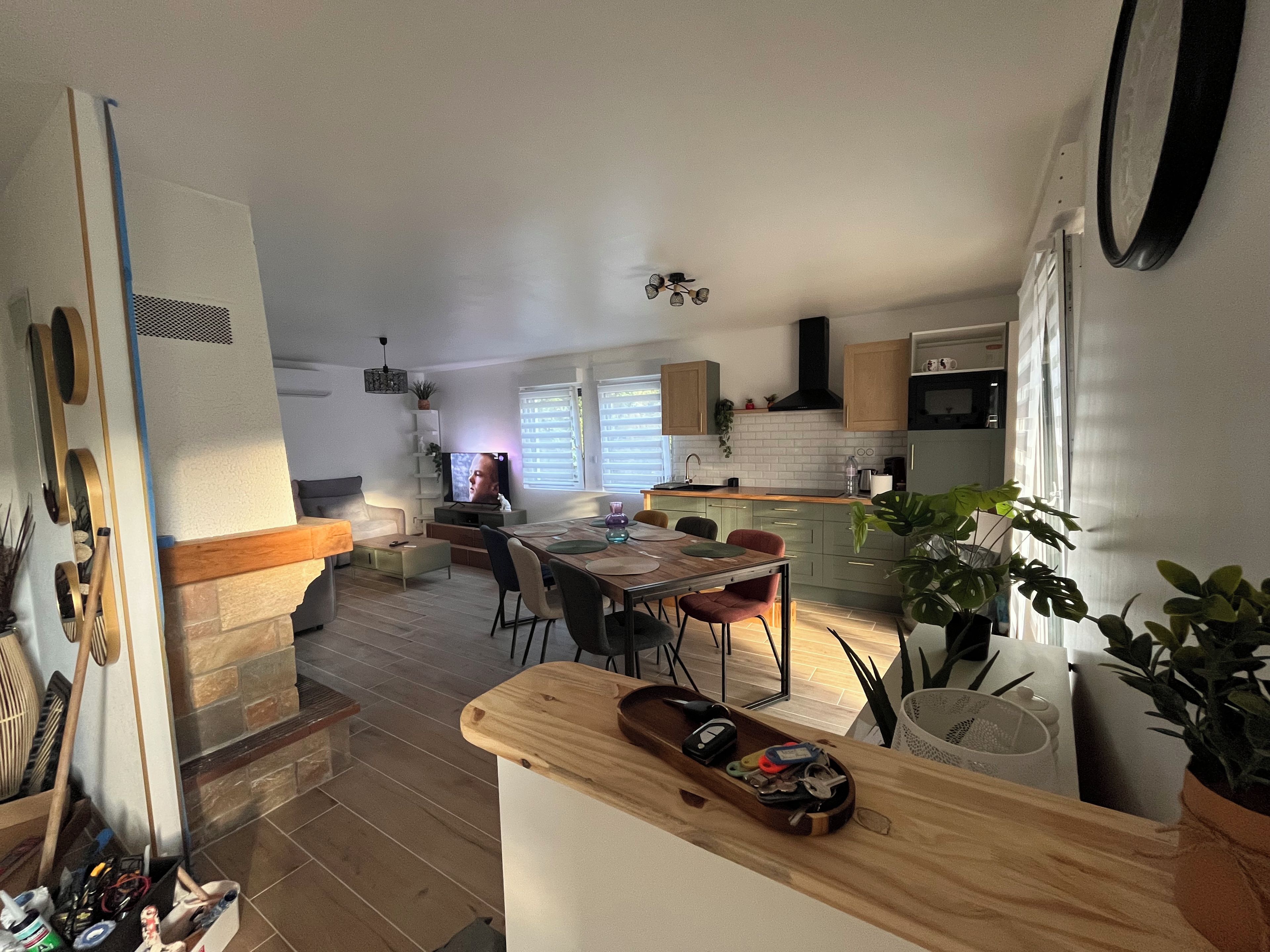 Une cuisine moderne avec un coin repas, des meubles en bois et un four encastré.