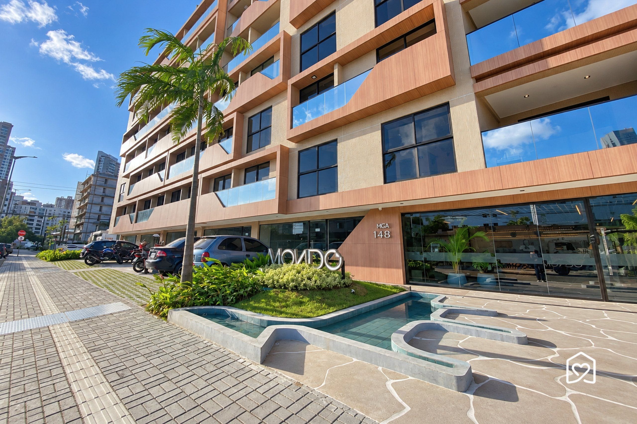 A modern building with a pool area, multiple floors, and a sign indicating the address.