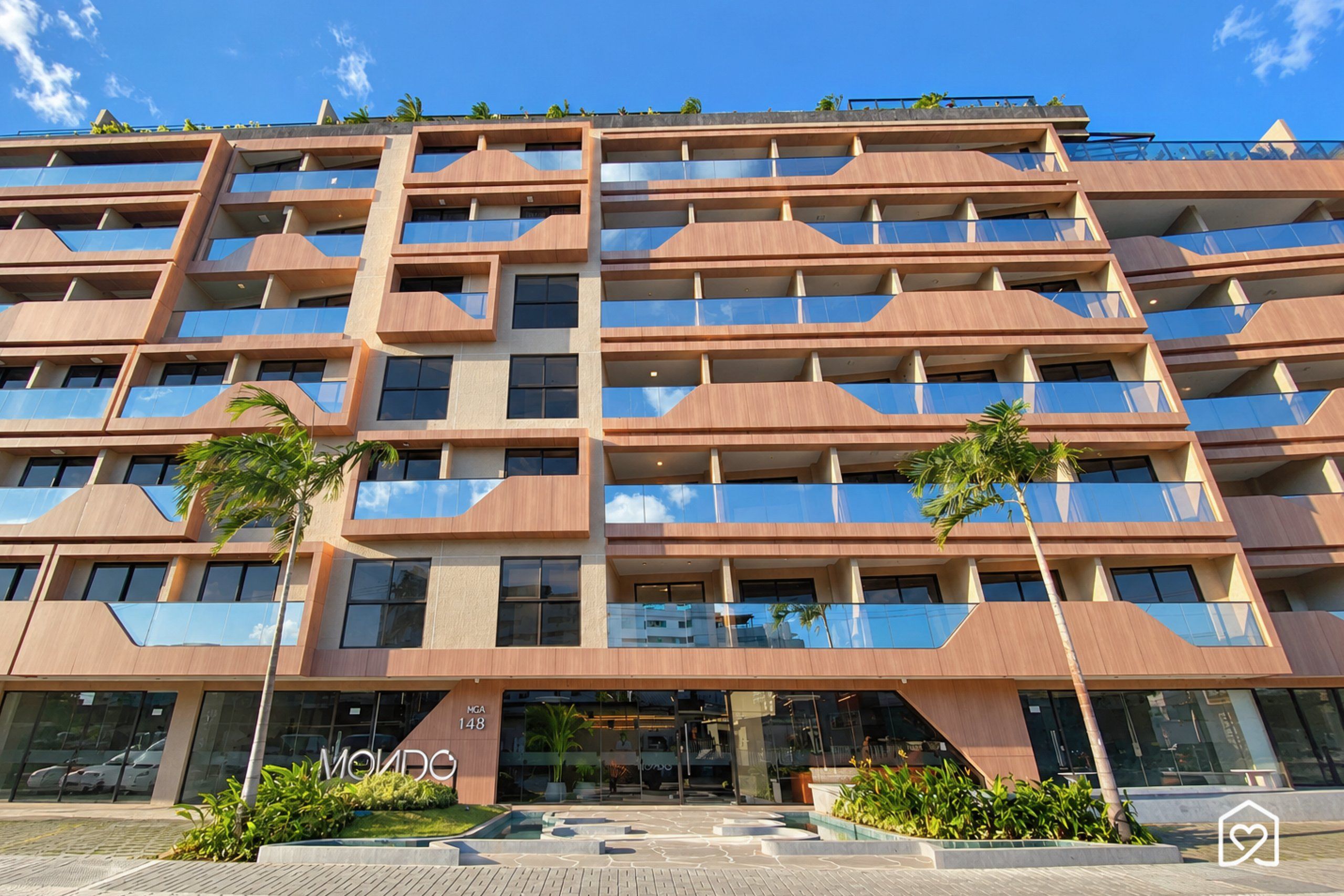 Ein mehrstöckiges Hotel mit moderner Architektur, mit Balkonen und einem begrünten Eingangsbereich.