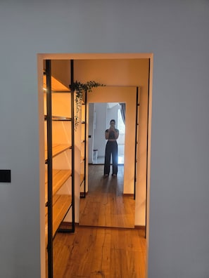A narrow hallway with wooden flooring leading to a room with a window. - Elegant Historic Apartment in the Heart of Vršac! (Vršac)
