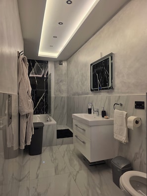 A modern bathroom with a marble floor, a white vanity, a black mirror, and a towel rack. - Elegant Historic Apartment in the Heart of Vršac! (Vršac)