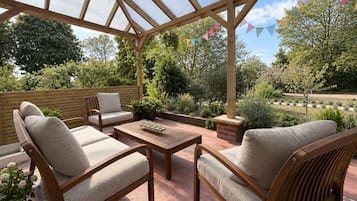 Un patio couvert avec des meubles en bois et un plafond en verre.