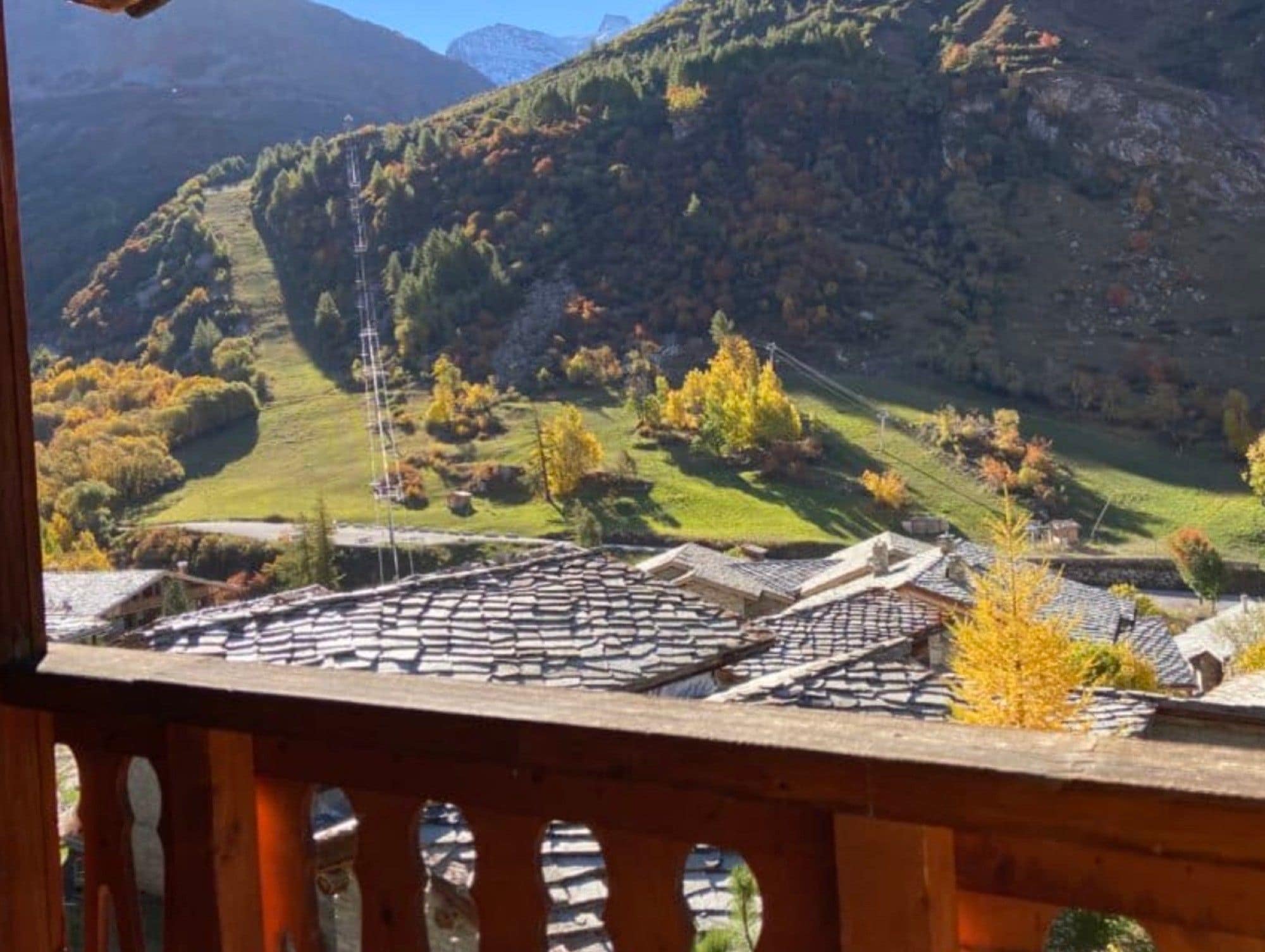 Paesaggio montuoso con un villaggio e un edificio tradizionale con tetto in tegole.