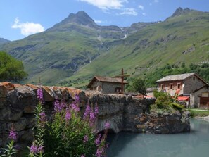 A mountainous landscape with a stone bridge, two rustic buildings, and a clear sky. - Apartment 'Le Bouvreuil Ouille Du Midi' with Mountain View (Bonneval-sur-Arc)