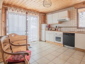 Eine Küche mit Holzausstattung, einem eingebauten Ofen und einem Geschirrspüler.