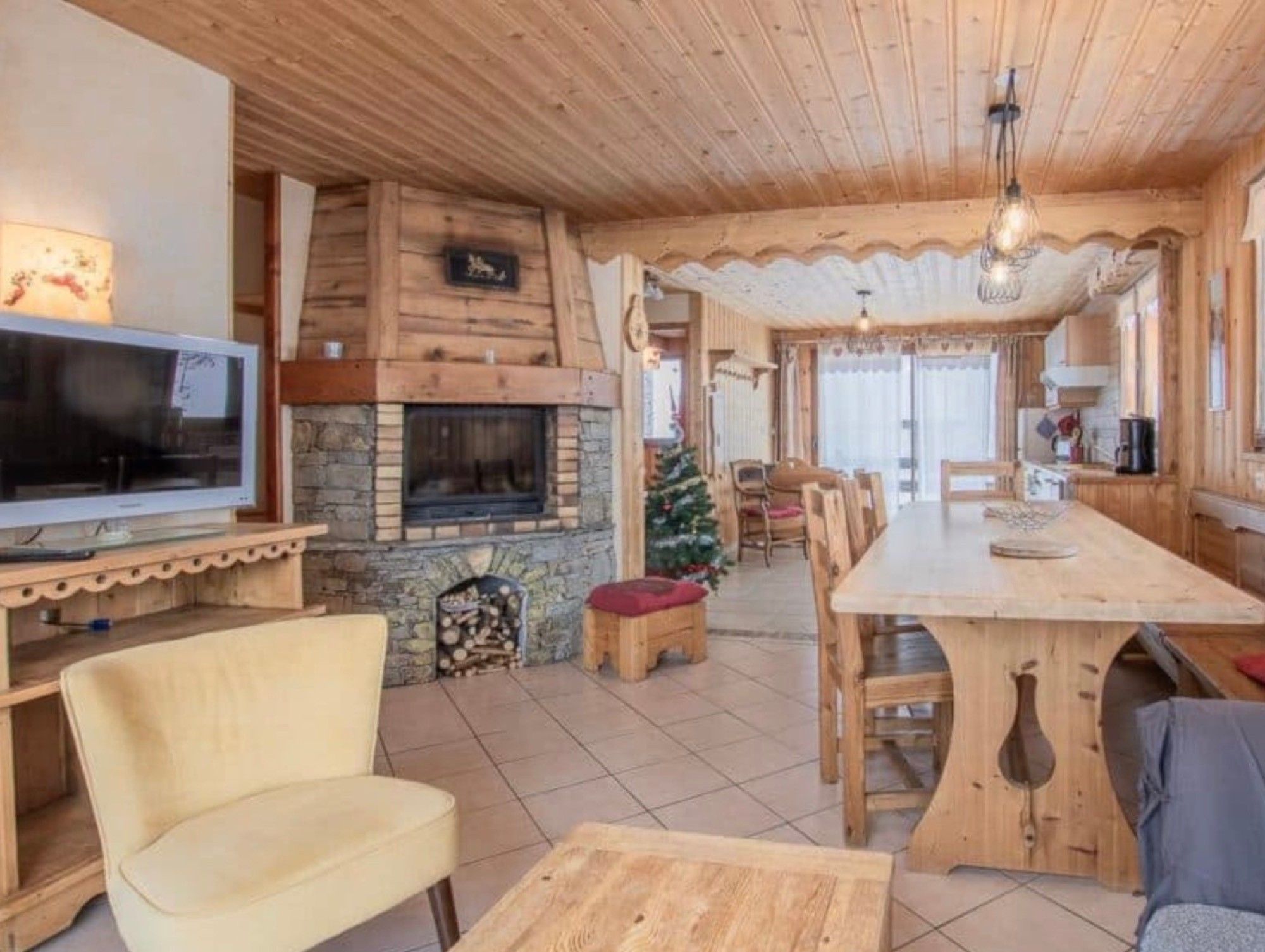 Un interno in legno con camino, televisione e zona pranzo.