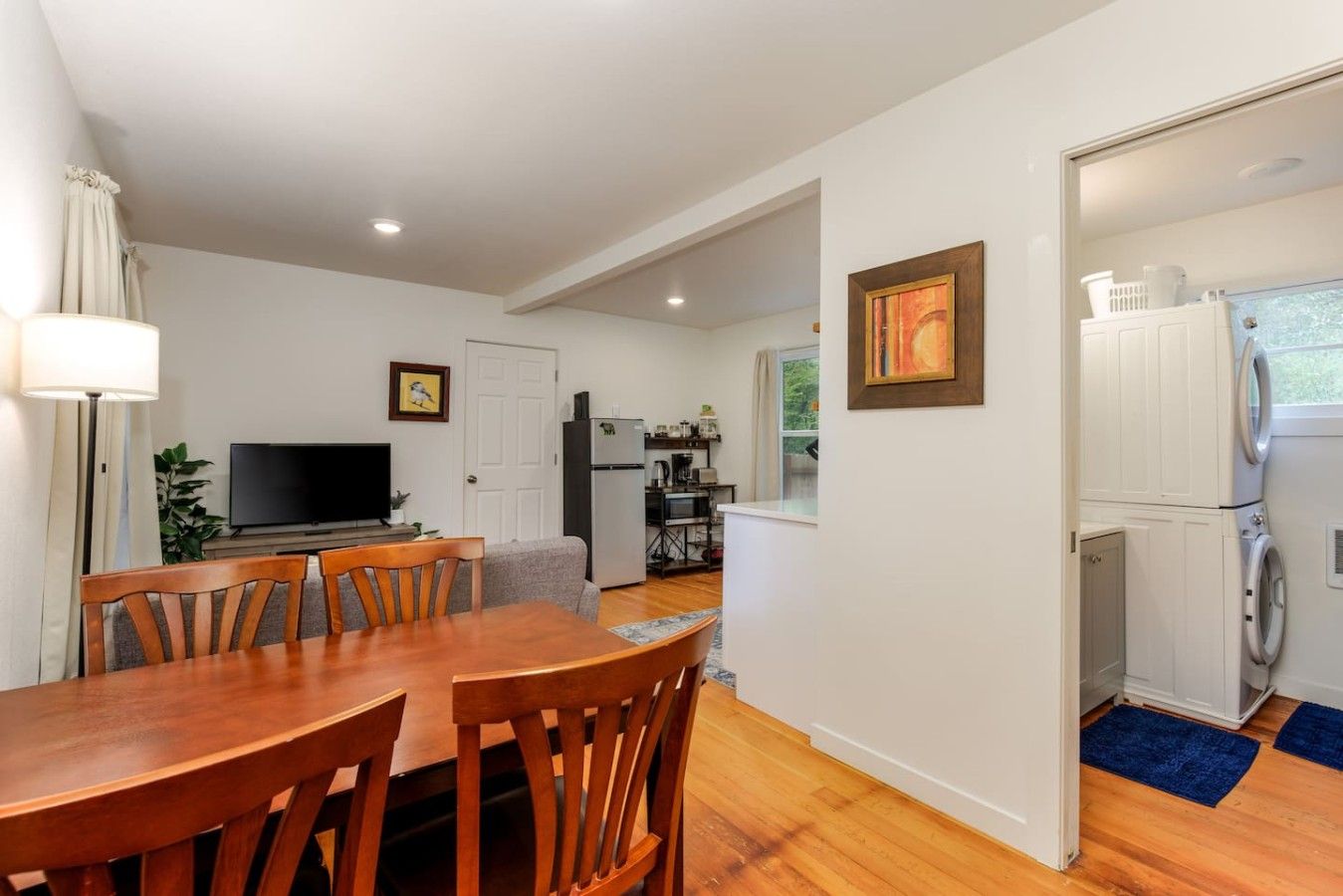 Un espace de vie compact comprenant un coin repas, une kitchenette et un espace buanderie.