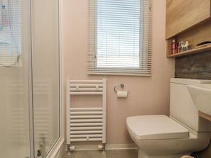 A bathroom with a glass shower enclosure, a toilet, a radiator, and a window with blinds. - 19 Finch (Scarborough)