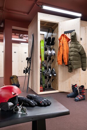Een skiopslagruimte met ski's, skischoenen en jassen.