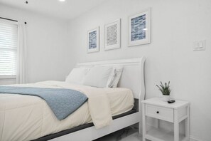 Ein Schlafzimmer mit Bett, Nachttisch und Wandbild.