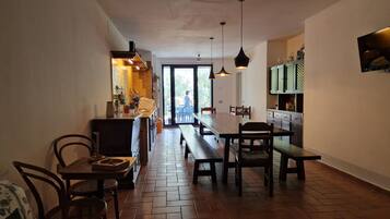 Une cuisine avec un coin repas, une grande fenêtre et une vue sur l’extérieur.