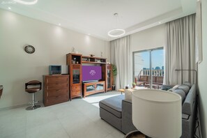 Ein modernes Wohnzimmer mit einer Couch, einem Fernseher und einem Holzkabinett.