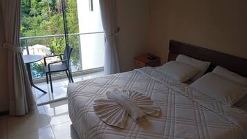 Habitación de hotel con una cama, una mesita de noche, una silla y vista a una piscina.