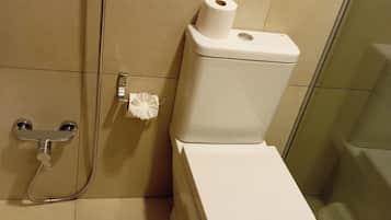 Ein Badezimmer mit Toilette, Dusche und Bidet.