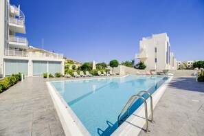 A swimming pool with sun loungers and a clear blue sky. - New: 2-Bedroom Family Apartment | Blu Horizon | Pool (Paralimni)