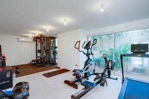 A home gym with a weightlifting station, an elliptical trainer, and a treadmill. - New: 2-Bedroom Family Apartment | Blu Horizon | Pool (Paralimni)