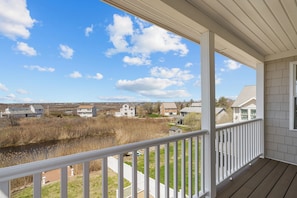 A wooden deck with a white railing overlooking a residential area and a body of water. - Walk to Roger Wheeler Beach - Water Views (Narragansett)