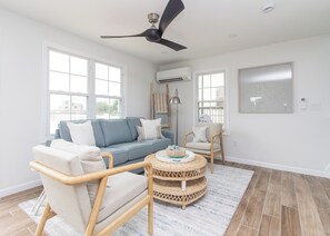 A modern living room with a sofa, chairs, a round coffee table, and a ceiling fan. - Walk to Roger Wheeler Beach - Water Views (Narragansett)