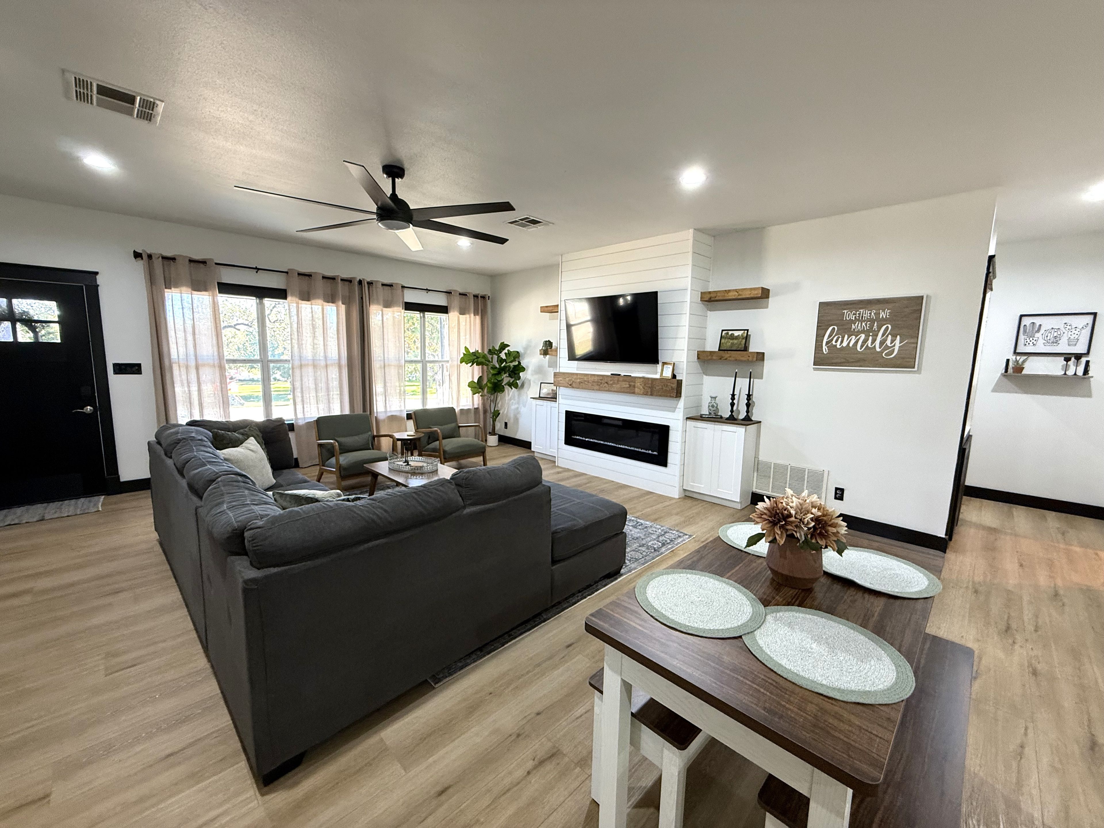 A modern living room with a sectional sofa, a flat-screen TV, and a fireplace.