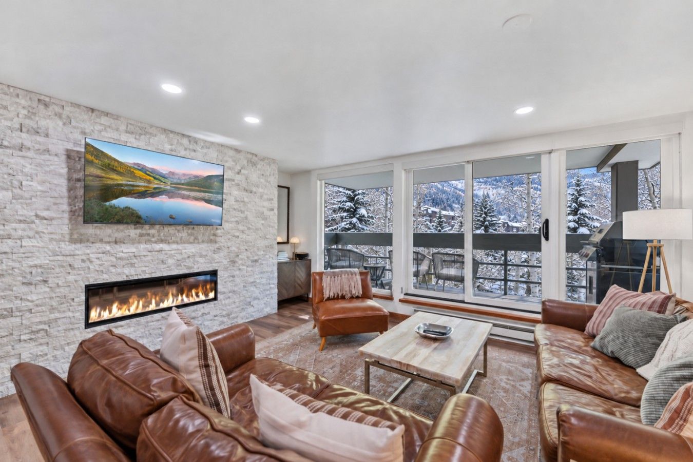 Cozy living room with fireplace, smart TV, comfortable seating and direct access to balcony