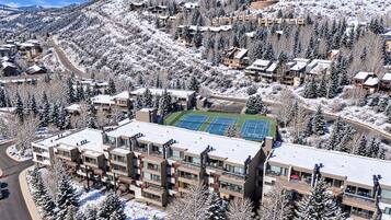 Aerial view of the condo complex, tennis courts, and surrounding mountain scenery