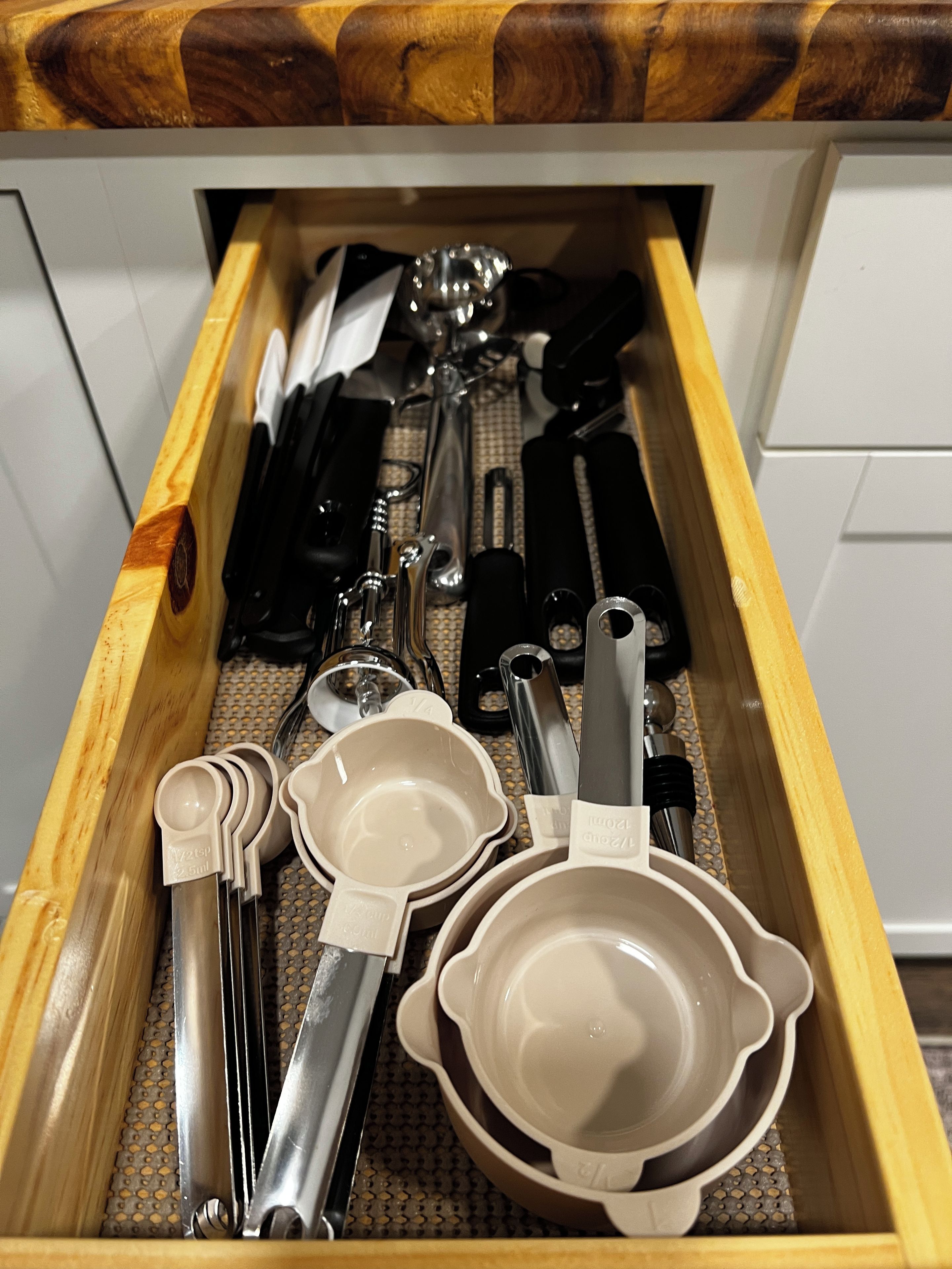 Un cassetto con utensili da cucina e strumenti di misurazione.