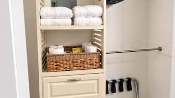 Ein begehbarer Kleiderschrank mit Regalen, Körben und einer Kleiderstange.