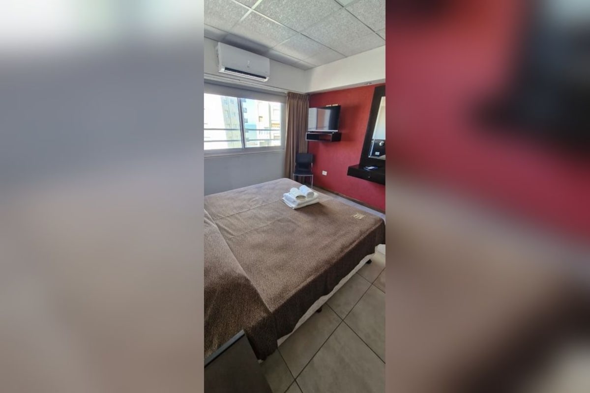 Ein Hotelzimmer mit einem Bett, einem Fernseher und einem Fenster.