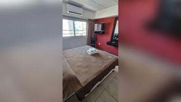 Una camera d'albergo con un letto, una televisione e una finestra.