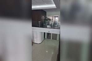 Zona de vestíbul amb taulell d'informació, escala i una planta.